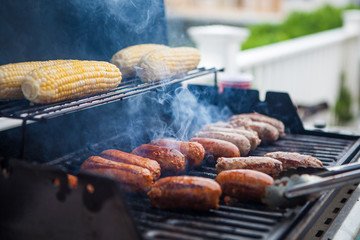 Corn and sausage on a summer gas grill barbecue being cooked