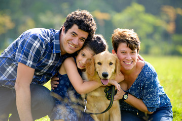 Happy family with a dog on a sunny day on a park