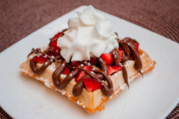 Belgian waffle with whip cream, caramel and strawberrys