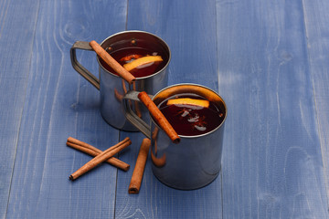 tea or mulled wine with cinnamon in metallic mug