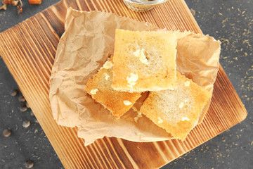 Tasty garlic French bread slices on wooden board