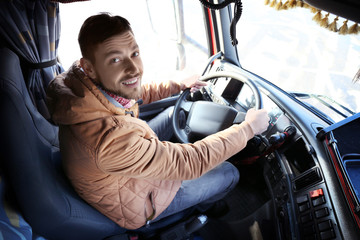Driver in cabin of big modern truck