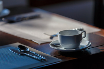 Close up of the white coffee mug on a wooden floor, Shadow light