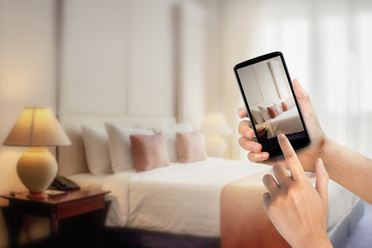 Woman hands using mobile phone take photo at hotel room blurred background