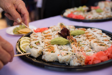 Catered sushi platter on purple table cloth at a party