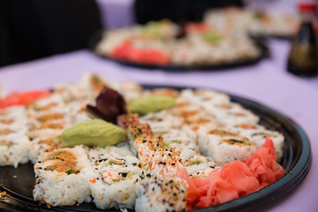 Catered sushi platter on purple table cloth at a party