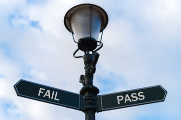 Fail versus Pass directional signs on guidepost