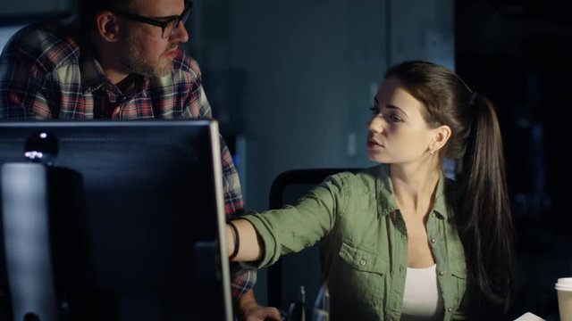  Late at Night in Engineering Firm, Male and Female Colleagues Discuss Drafts and Work on Computer.  Shot on RED Cinema Camera 4K (UHD). 