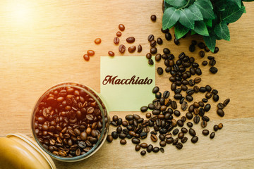 Business Concept, Top view showing a jar of coffee beans,leaf pot and a sticky written MACCHIATO