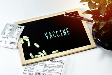 Medicine over the board written VACCINE on white isolated background