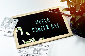 Medicine over the board written WORLD CANCER DAY on white isolated background