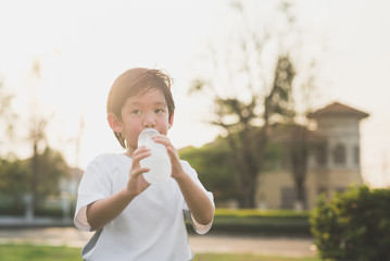 Fototapeta premium sian boy drinks water from a bottle