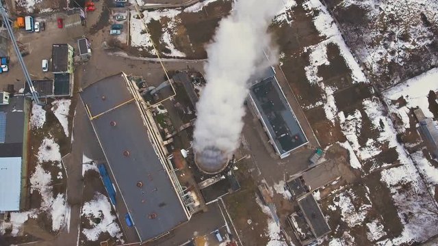 Top of the pipe with steam during the winter heating season (aerial shot). 4K. Pipes of a thermal power plant.