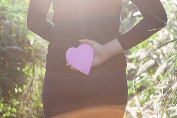 Secretly in love concept, heart concealed on the back. Backlight Lens Flare