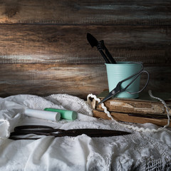 still life with scissors, crayons and lace on a background of rough wooden walls. vintage