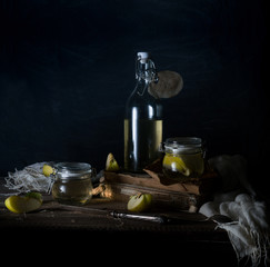 still life with apples, apple juice, old books and a silver knife on a wooden table on a dark background. vintage