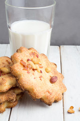 glass of milk and cookies with peanuts on a white background closeup