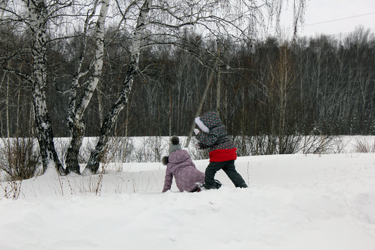 Two girls walking and playing in the winter forest and having fun with snow 29995