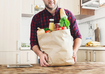 Man holding a paper bag full of healthy food