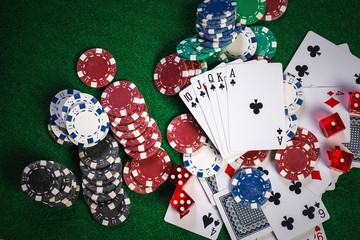 Poker chips and cards on casino gamble green table with royal fl