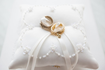 Wedding Rings on White Pillow with Lace and Beads.