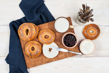 Fresh homemade Poppy bagels bread with cup of milk, cream cheese
