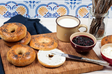 Fresh homemade Poppy bagels bread with cup of milk, cream cheese