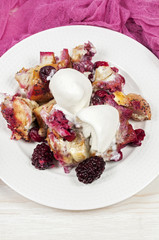 French toast casserole with berries and vanilla ice cream on whi