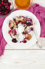 French toast casserole with berries and vanilla ice cream on whi