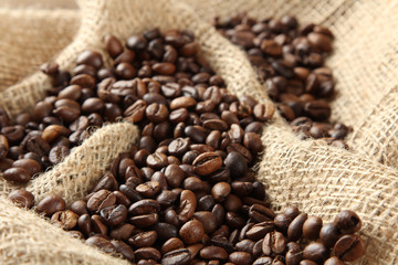 Handful of roasted coffee on the sack.