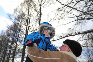 Parent holding kid on hands in winter park