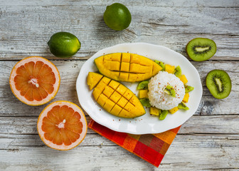Fresh mango and kiwi with rice on white plate. 