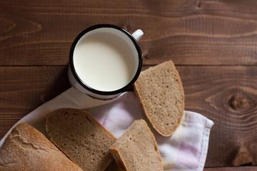 Чашка с молоком и хлебом на столе. 