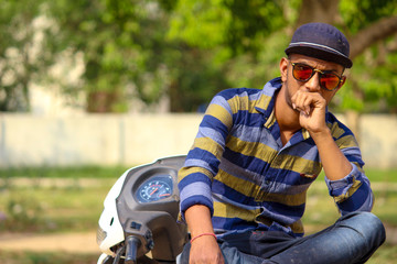 Asian Male Model Is Sitting On The Bike He Is A Wear A Sunglasses With The Cap 