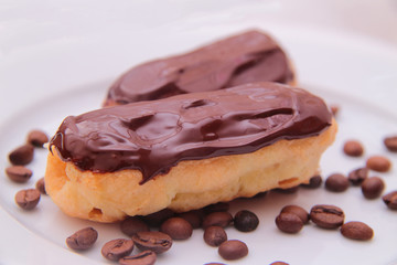 Chocolate eclairs on plate on white background