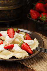 Delicious dumplings with fresh strawberries served with whipped