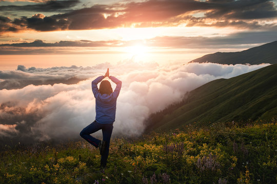 woman in the mountains during a foggy dawn exercise in yoga