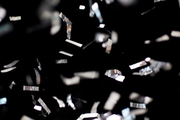 silver confetti over black background