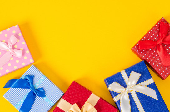 Many color gift box on yellow color background.