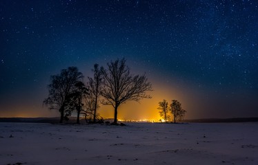 Fototapeta na wymiar Night landscape with starry sky and village lights.