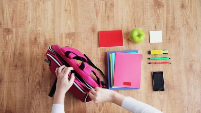 hands packing schoolbag