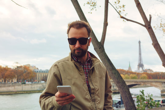 Modern man using cellphone in the European city.