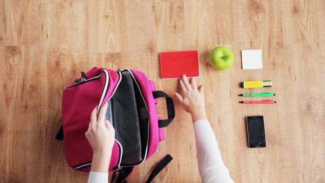 hands packing schoolbag