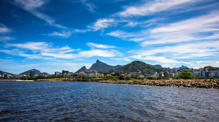 Cityscape view of Guanabara Bay and embankment at sunny day with blue sky, white spindrift clouds...