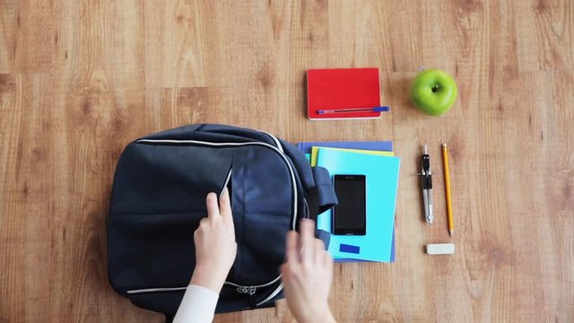 hands packing schoolbag