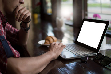 Young man freelancer working from a cafe with a laptop, hipster guy using modern laptop computer while working in a vintage loft, close-up of male hands.
