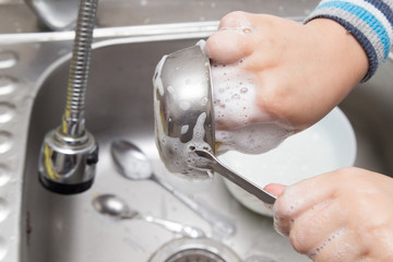 boy washing dishes in the kitchen