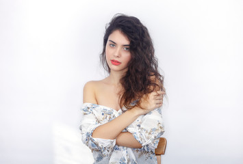Naklejka premium Beauty portrait of young adorable fresh looking brunette woman with crossed hands. Emotion and facial expression concept.