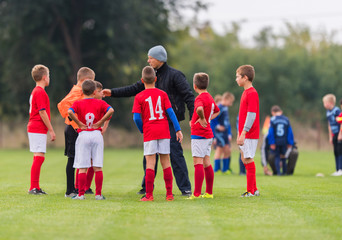 Obraz premium Children soccer players playing football and coaches training th