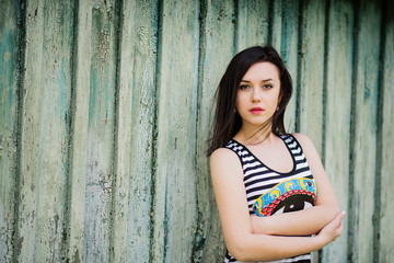 Fototapeta premium Brunette model girl at dress with stripes background cian wooden
